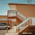 girl in blue denim dungaree pants holding blue and white polka dot handbag